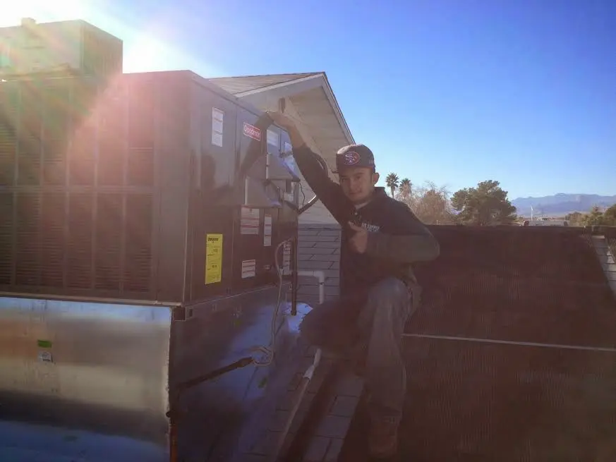 HVAC technician performing AC Tune-Up on a rooftop unit in Russellville